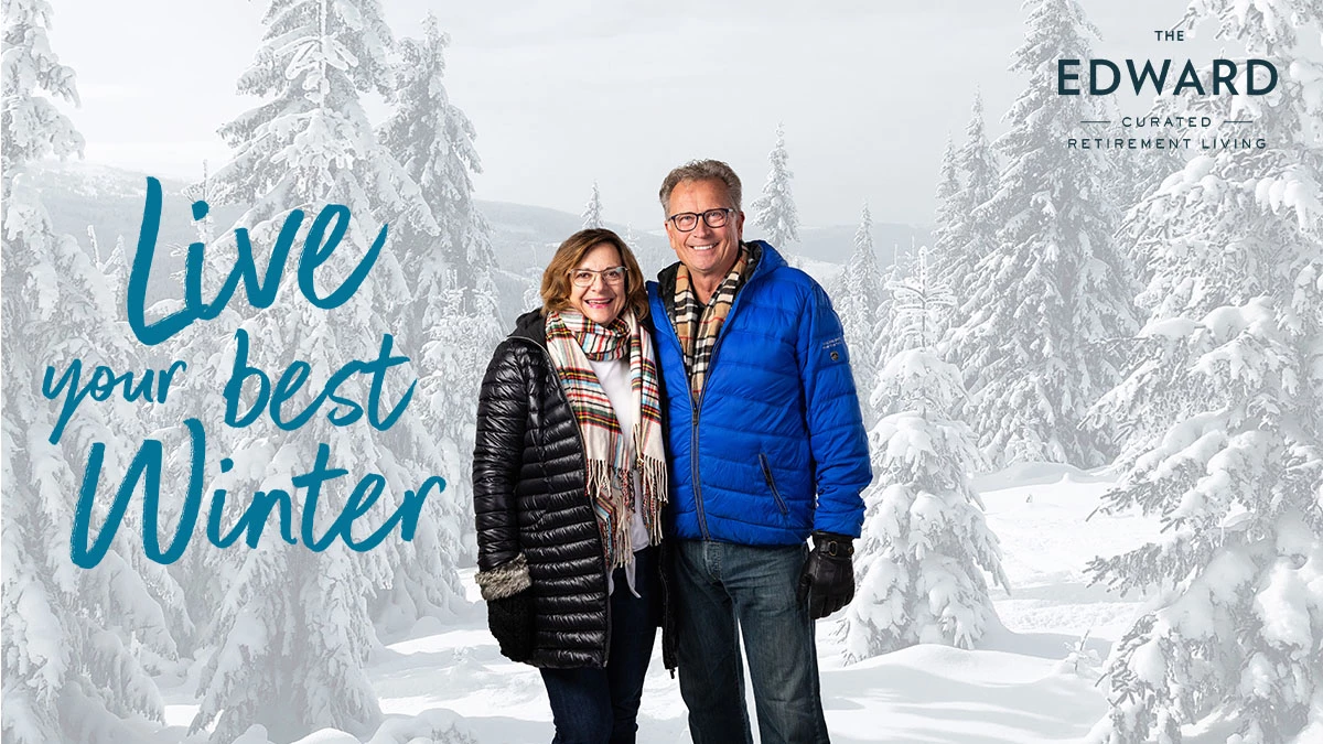 Senior couple standing in winter coats with live your best winter text to the left of them.