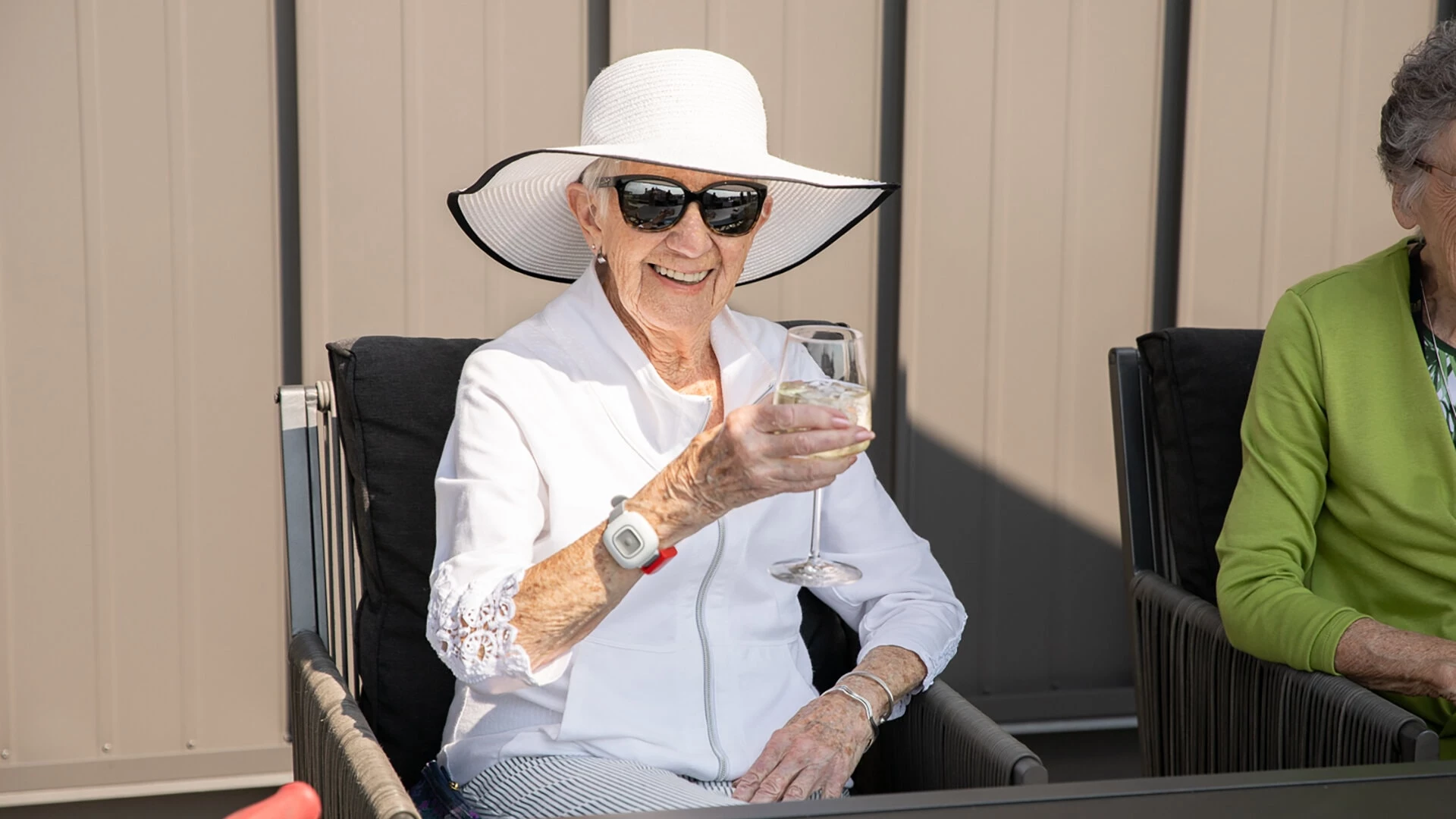 A senior woman drinking a glass of white wine with ice