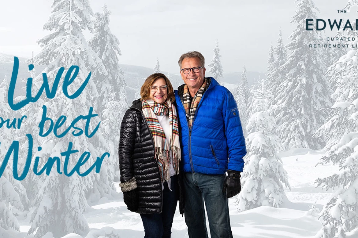 Senior couple standing in winter coats with live your best winter text to the left of them.